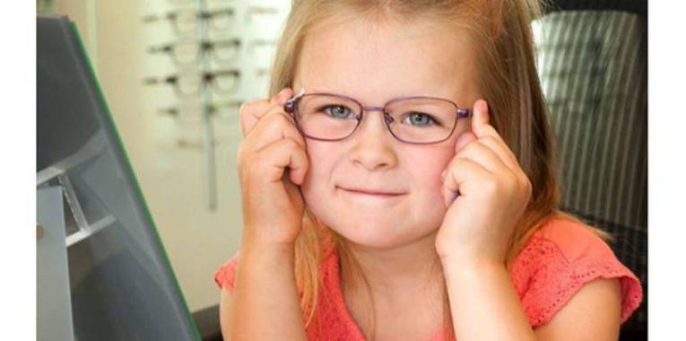 kindergarten child trying on eyeglasses