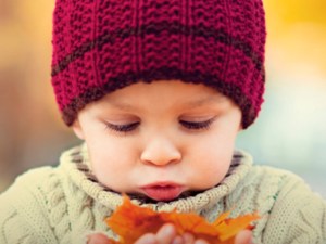 young child looking at leaves